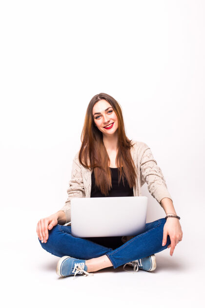 成人年轻随意的女人坐下来微笑着拿着笔记本电脑女人地板坐