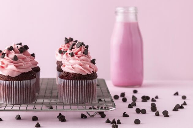 糖衣粉红色糖衣纸杯蛋糕和粉红色饮料甜点可口美味