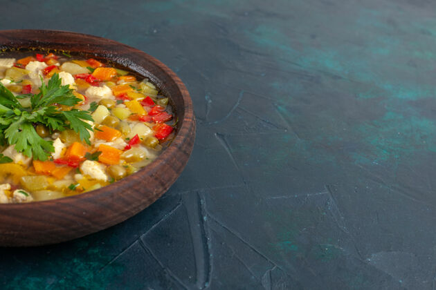 汤在黑暗的桌子上的棕色盘子里 可以看到不同配料的美味蔬菜汤午餐膳食美味