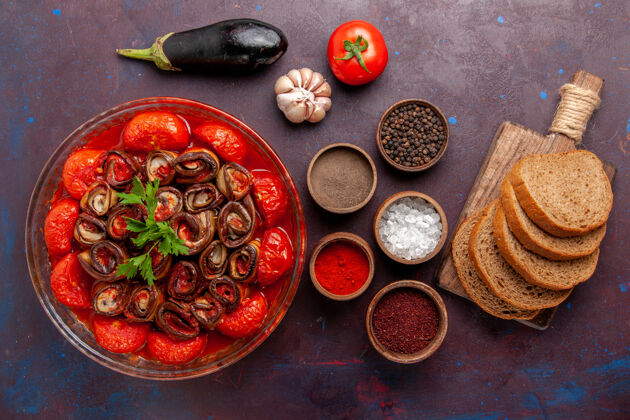 面包顶视图熟蔬菜餐番茄和茄子与调味品面包在黑暗的表面调味品顶部桌子