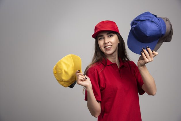 制服一个穿着红色制服 戴着彩色帽子的送货员女送货职业