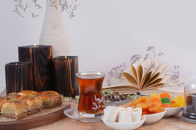 杏干在大理石桌上放一杯茶 糖果和传统的各种烤肉糖杯子顶视图