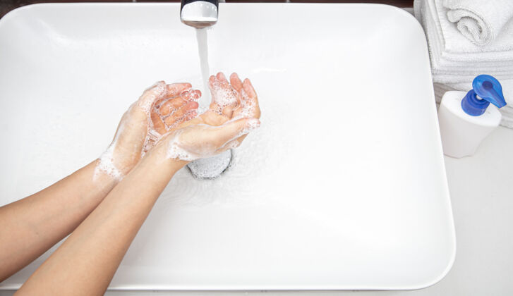 洗手液在自来水下用肥皂水洗手个人卫生和健康的概念泡沫手卫生