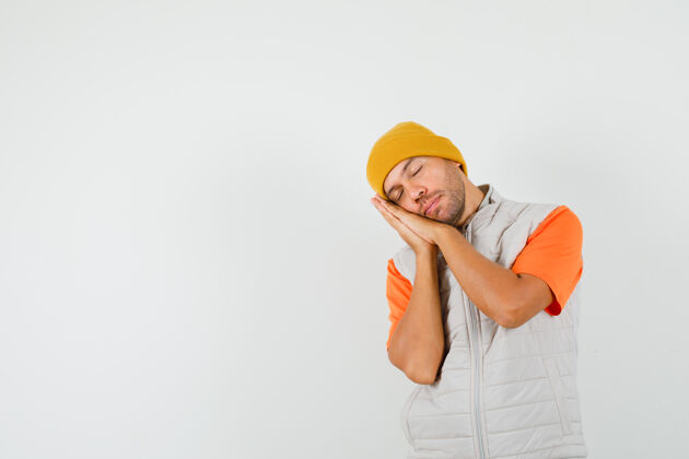 枕头一个年轻人 穿着t恤 夹克 戴着帽子 用手掌做枕头 看上去很放松正面图休闲友好衬衫
