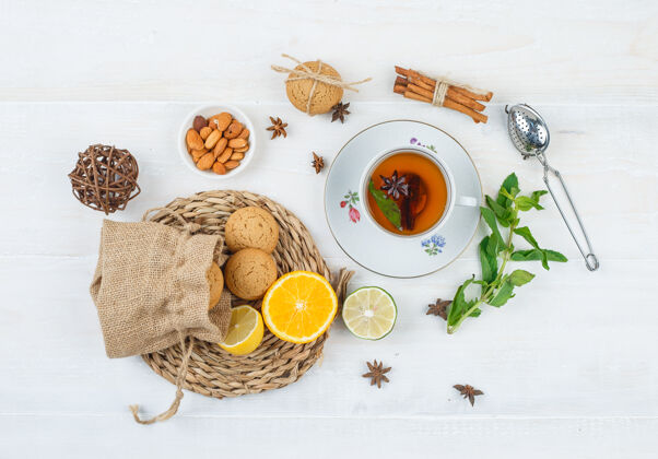 杏仁一杯茶 一碗杏仁和一个滤茶器 放在圆形餐垫上的巧克力和饼干新鲜的甜的传统的