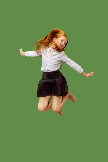 表情年轻快乐的白人少女在空中跳跃 孤立在绿色美丽的女性半身像手臂可爱快乐