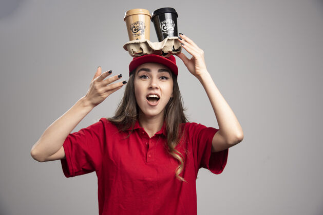 咖啡头上顶着咖啡杯的漂亮女人女人职业工人