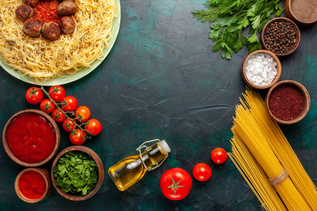 乐器在蓝色的桌子上俯瞰美味的意大利面食 里面有肉丸子和不同的调味品意大利语盘子调味品