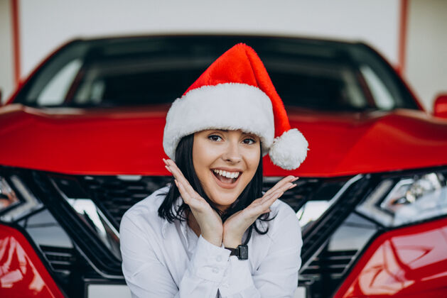 商店圣诞节在汽车陈列室戴圣诞帽的女人圣诞礼物彩票信心