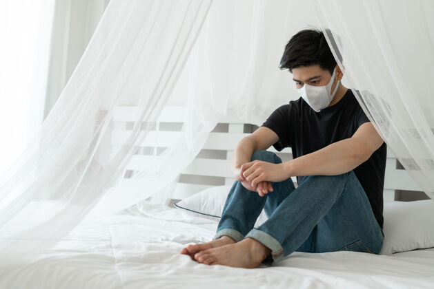 健康亚洲男子戴口罩以防在检疫室因冠状病毒冠状病毒-19而感到头痛和咳嗽诊所面罩病毒传播