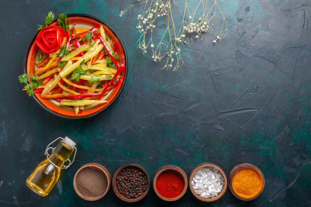 铃铛顶视图切片甜椒健康沙拉橄榄油和调味品深蓝色背景健康带子胡椒