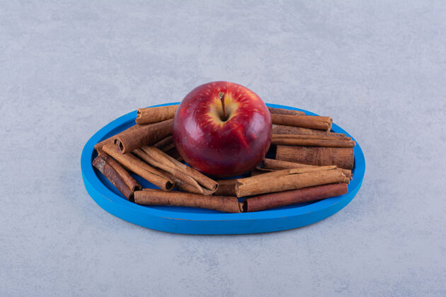 棒蓝色的盘子里放满了肉桂和苹果食品健康多汁