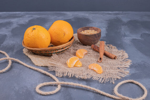 柑橘新鲜的橘子放在碗里 肉桂放在蓝色的表面上天然多汁成熟
