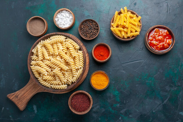 核桃在深蓝色的桌子上可以俯瞰意大利面食和调味品意大利食物种子