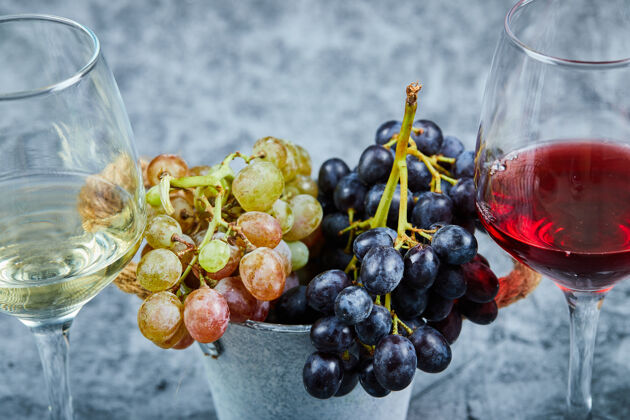 酒庄一大串白葡萄和黑葡萄 两杯白葡萄酒和红葡萄酒配上蓝葡萄酒酒杯食品天然