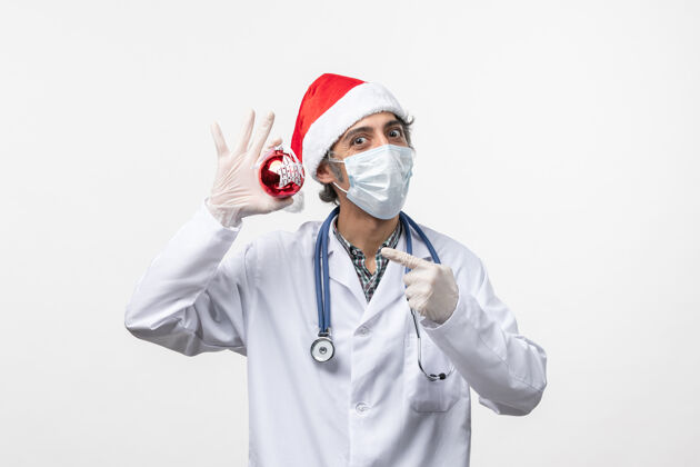 外套正面图男医生戴着口罩和玩具上白墙病毒冠状病毒健康过年听诊器药品实验室外套
