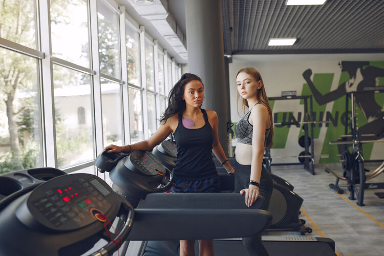 早晨健身房里的漂亮女孩穿着运动服的运动女士赛道上的朋友训练赛马场锻炼