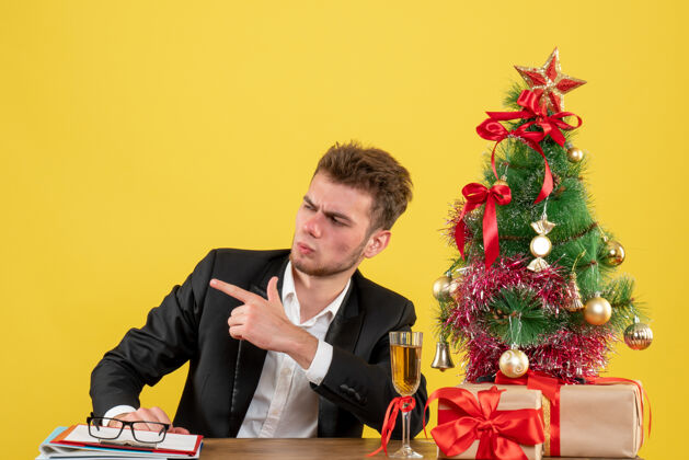 行政人员正面图：坐在黄色工作台后面的男工人地点年圣诞节