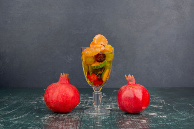 浆果大理石桌上摆着一杯混合水果和石榴柑橘葡萄玻璃