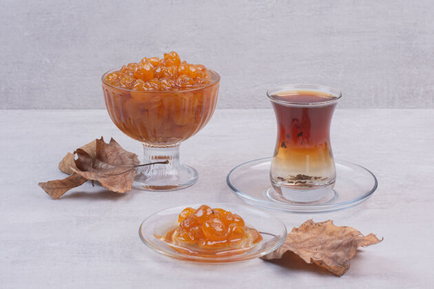 果酱一杯白茶和浆果酱 配上叶子甜味有机玻璃