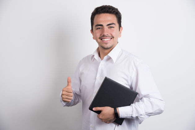 微笑商人拿着笔记本电脑 在白色背景上竖起大拇指笔记本电脑肖像电子产品