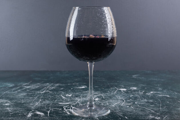 杯子蓝色桌子上放一杯加冰的葡萄酒滴酒桌子