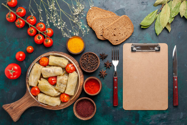 美味俯瞰图美味的肉食卷心菜内卷面包和新鲜西红柿在深蓝色的桌子上西红柿一餐肉