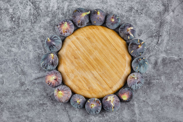 异国情调紫色无花果围绕在大理石的木板上成熟水果甜味