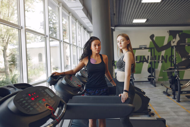 早晨健身房里的漂亮女孩穿着运动服的运动女士赛道上的朋友训练赛马场锻炼