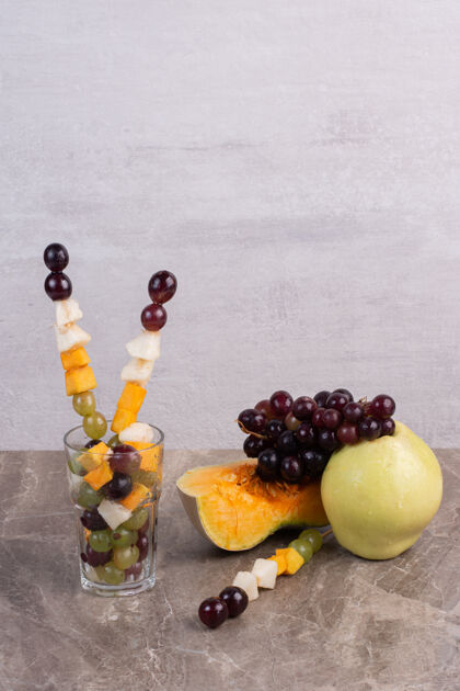 葡萄大理石表面有水果棒和新鲜水果瓜食用南瓜