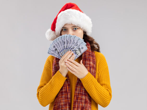 举行带着圣诞帽 脖子上围着围巾 手里拿着钱的焦急的斯拉夫女孩新年圣诞快乐新