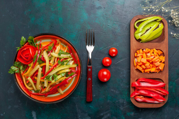 颜色顶视图切碎的甜椒不同颜色的蔬菜沙拉 配料在深蓝色的背景上切片辣椒盘子