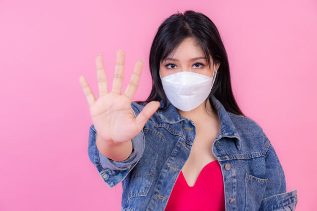 医生戴着口罩的亚洲女孩展示停止手势 为阻止冠状病毒爆发 保护传播covid-19停止手加上亚洲人