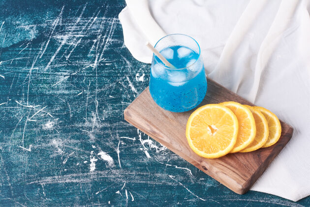 酸橘子片和一杯饮料放在蓝色的上面冰沙顶部生物