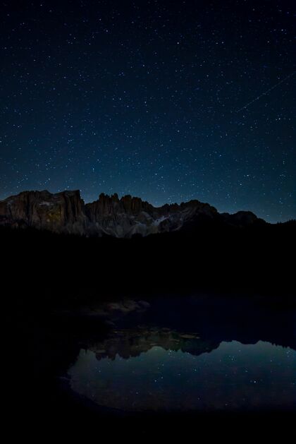 峡谷星空和岩石峭壁的壮丽景色在夜晚映照在湖面上星座悬崖天文学