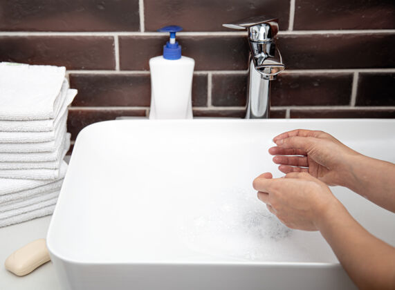 手在浴室里用自来水洗手个人卫生和健康的概念个人卫生泡沫洗手液