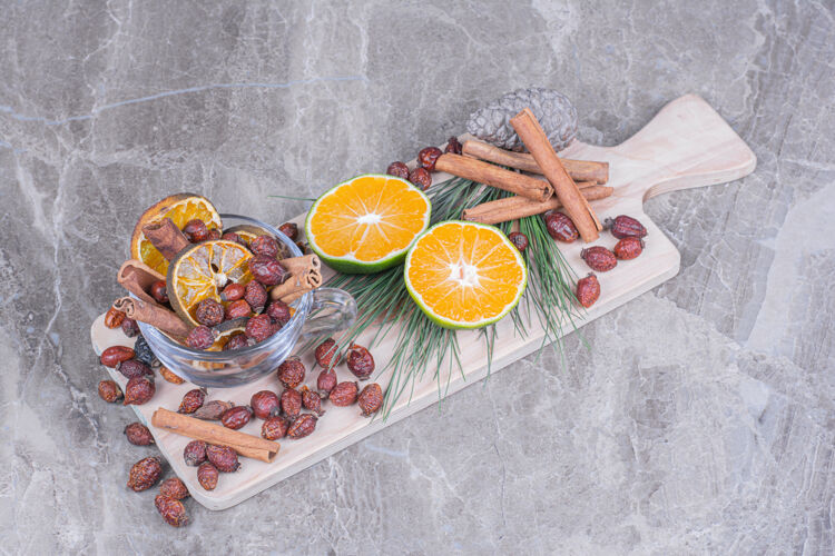 味道干的臀部和橘子片 在木板上放新鲜的橘子美味圣诞节蔬菜