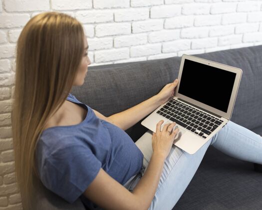事业孕妇坐在沙发上用笔记本电脑工作的高角度怀孕女性职业