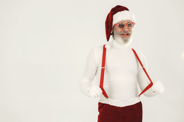 疯狂时髦的灰色头发的圣诞老人男人穿针织衣服爷爷戴着圣诞老人的帽子现代帽子老年人