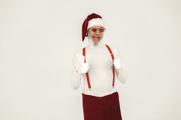 聚会时髦的灰色头发的圣诞老人男人穿针织衣服爷爷戴着圣诞老人的帽子乐趣节日胡须