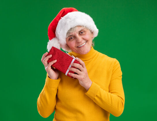 紫色圣诞老人戴着圣诞帽 手里拿着圣诞礼盒举行礼物盒子