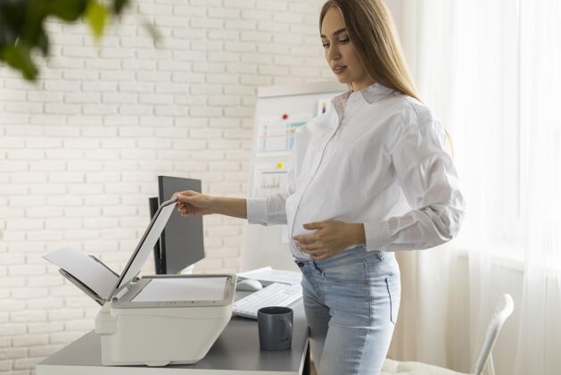 职业孕妇在办公室使用扫描仪的侧视图女商人女人电脑