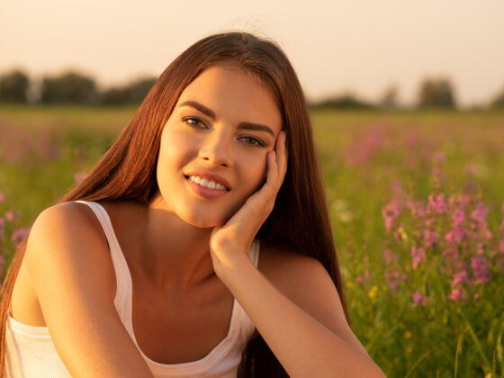 华丽美丽性感的女孩是在春天的野花背景上自然肖像草地田野