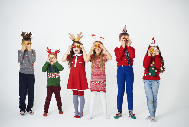 圣诞节顽皮的孩子们把弓举在眼前装饰装饰站着