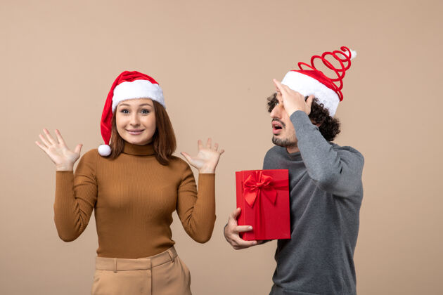 可爱的情侣新年气氛喜庆的概念与搞笑快乐集中可爱的情侣戴着灰色的红色圣诞老人帽帽子成人服装