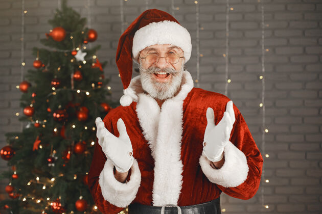 快乐圣诞老人站在圣诞树旁家装庆祝胡须圣诞节