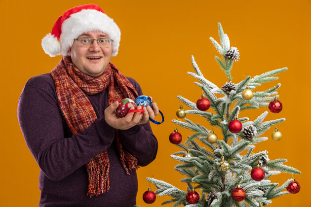圣诞快乐的成年人戴着眼镜 戴着圣诞帽 脖子上围着围巾橙色眼镜男人