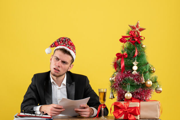 工作正面图男性工人坐在他工作的地方后面 黄色的文件颜色男圣诞节