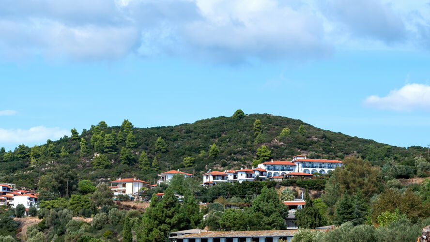 老年人在希腊乌拉努波利斯 一座被郁郁葱葱的绿色植物覆盖的小山上 几栋风格相同的建筑尽收眼底希腊爱琴海度假