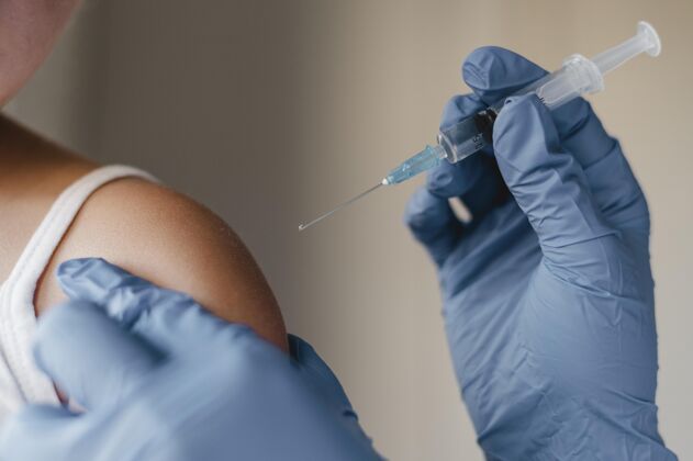 防护戴手套的医生给小孩注射疫苗注射器健康药品